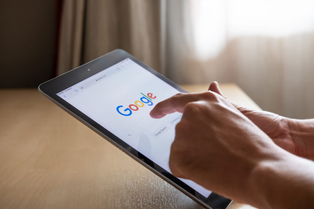 Bangkok, Thailand 25 AUG 2020. Men hand using digital tablet for search information on Google. Wireless Smartphone technology with intelligence search engine.