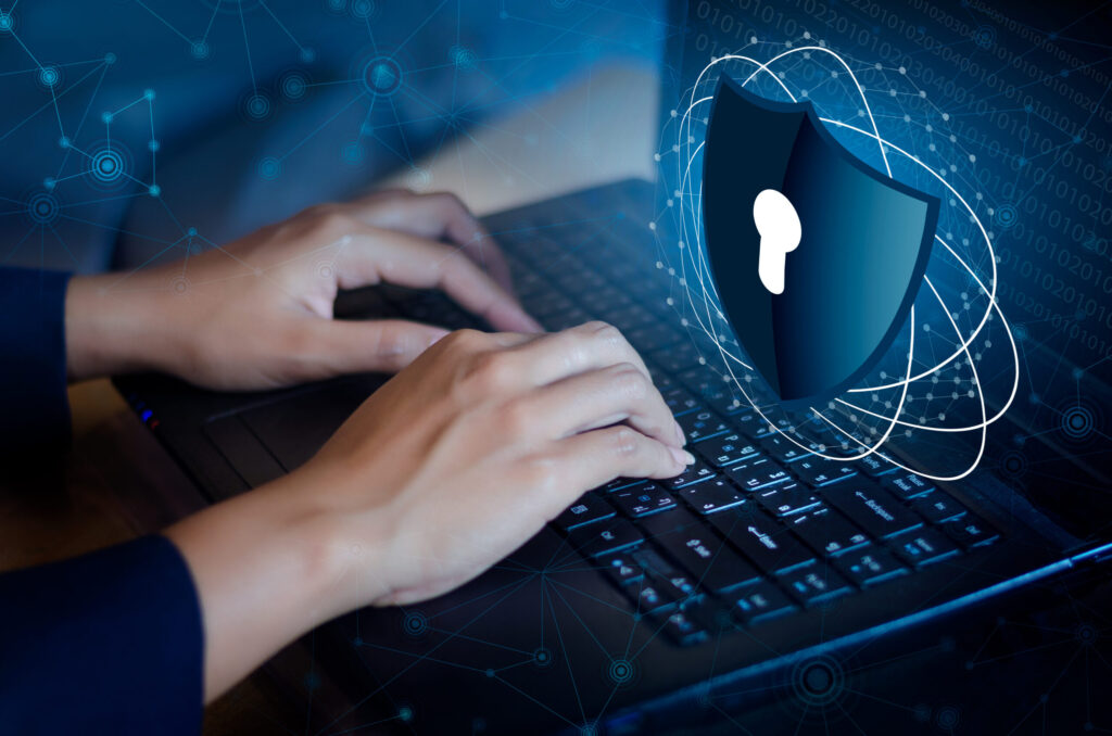 Cybersecurity: A woman typing on a keyboard next to a shield that represents cyber security.